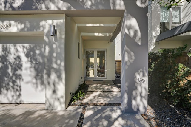 view of exterior entry with french doors and a garage