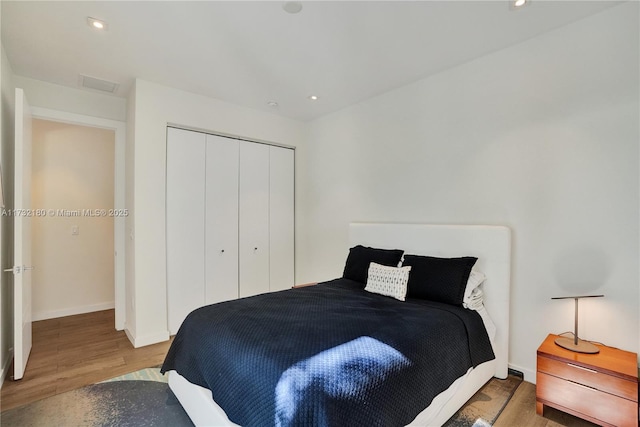 bedroom with wood-type flooring and a closet