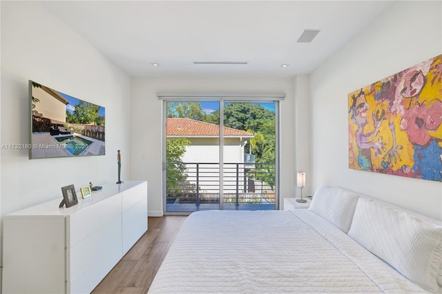 bedroom with access to exterior and light hardwood / wood-style flooring