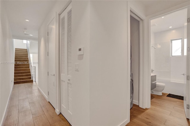 corridor featuring washer / dryer and light wood-type flooring