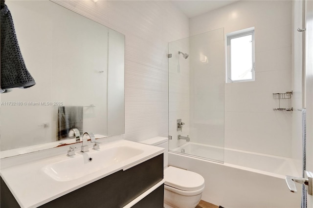 full bathroom with vanity, tiled shower / bath combo, and toilet