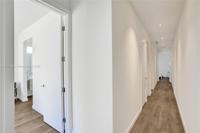 corridor with light hardwood / wood-style flooring