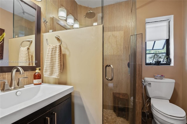 bathroom featuring an enclosed shower, vanity, and toilet