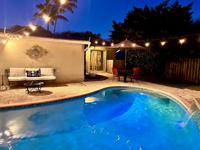 18020 SW 89th Ave, Palmetto Bay, FL 33157 - pool at night with a patio area, outdoor lounge area, fence, and a fenced in pool