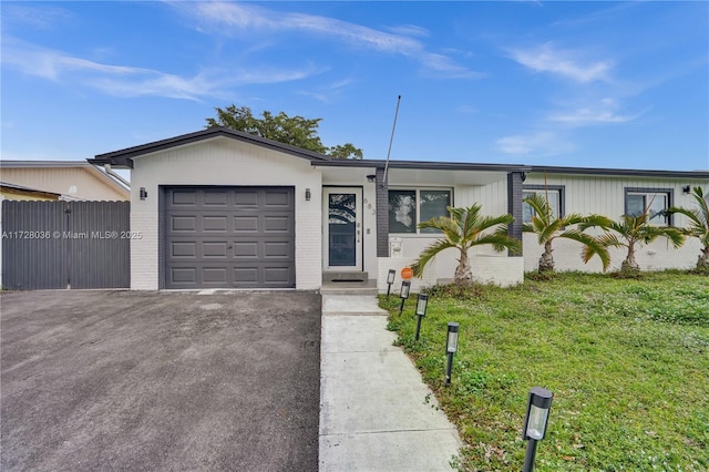 single story home featuring a garage and a front lawn