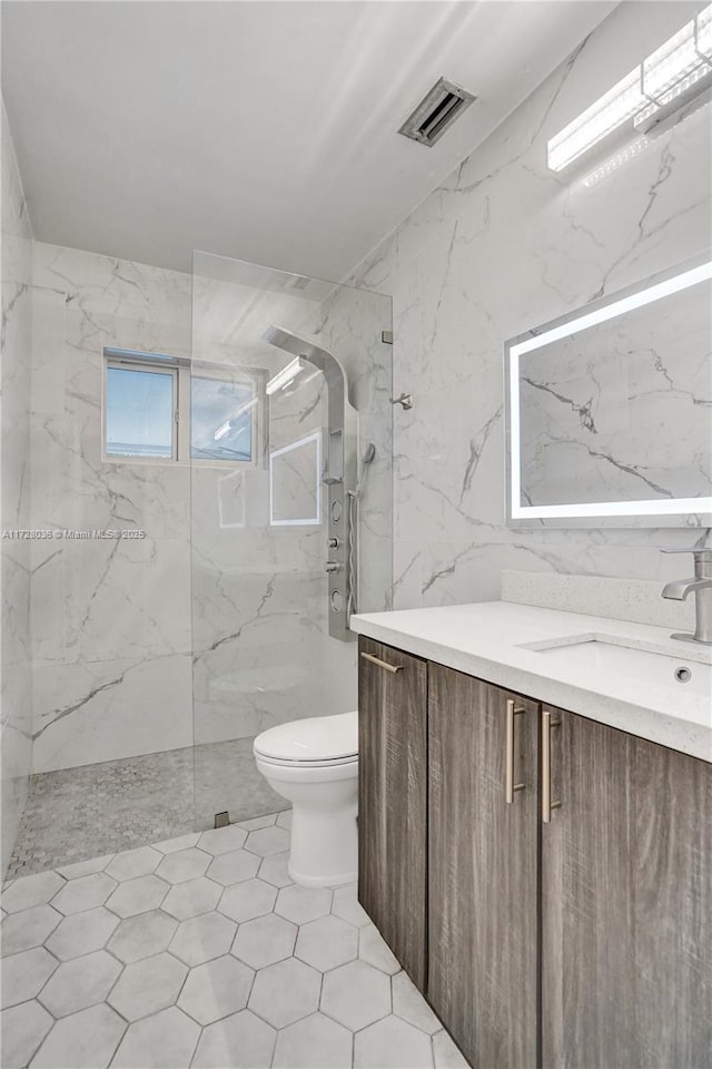 bathroom with vanity, toilet, tile walls, and a tile shower