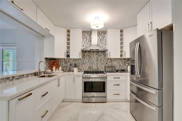 kitchen featuring wall chimney range hood, sink, stainless steel appliances, white cabinets, and decorative backsplash