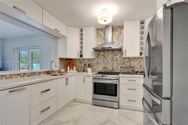 kitchen featuring white cabinetry, appliances with stainless steel finishes, sink, and wall chimney range hood