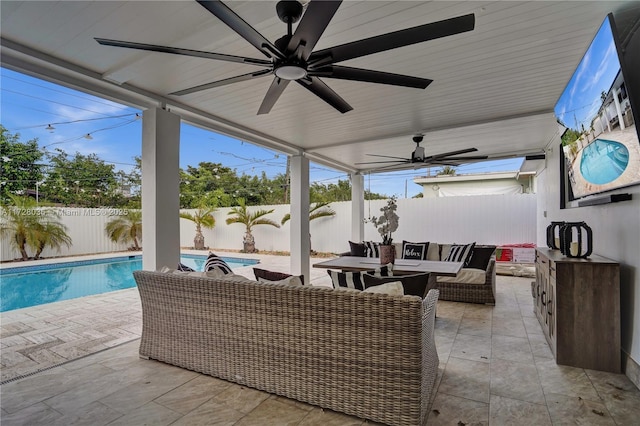 view of patio / terrace featuring a fenced in pool, ceiling fan, exterior bar, and an outdoor hangout area