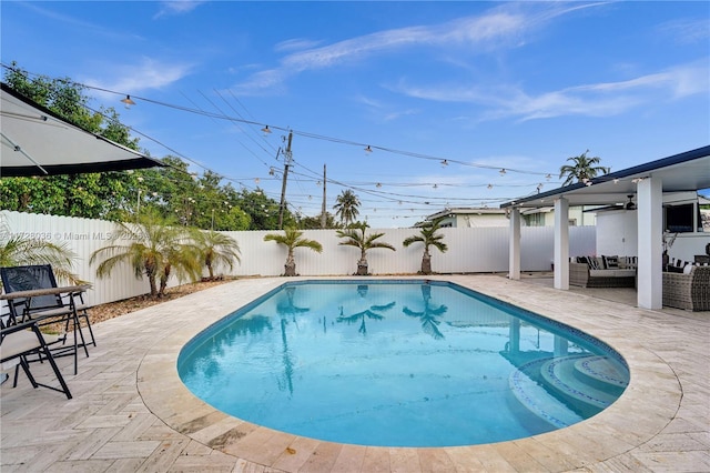 view of swimming pool with ceiling fan, an outdoor hangout area, and a patio