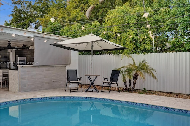 view of swimming pool with an outdoor bar and ceiling fan