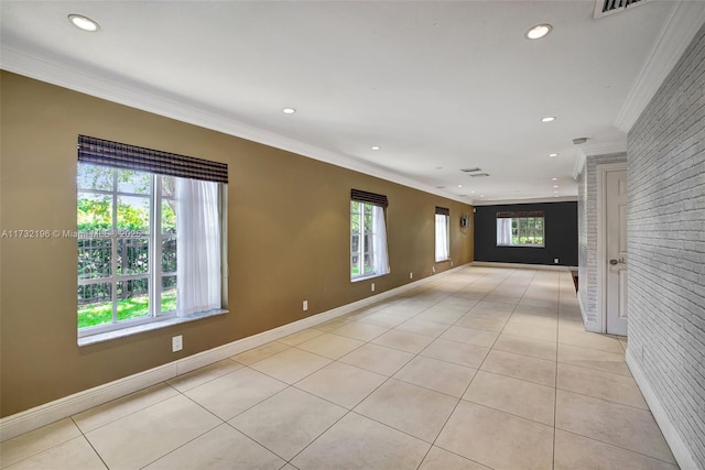 empty room with crown molding, brick wall, and light tile patterned flooring