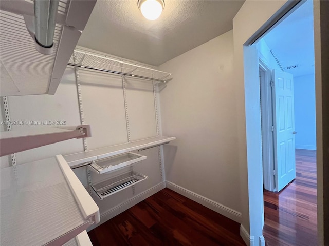 spacious closet featuring dark hardwood / wood-style floors