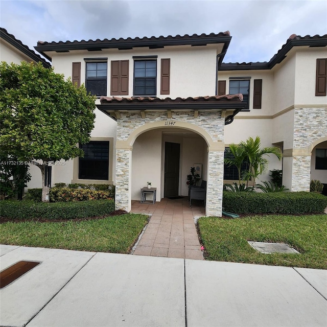 mediterranean / spanish-style home with a front lawn