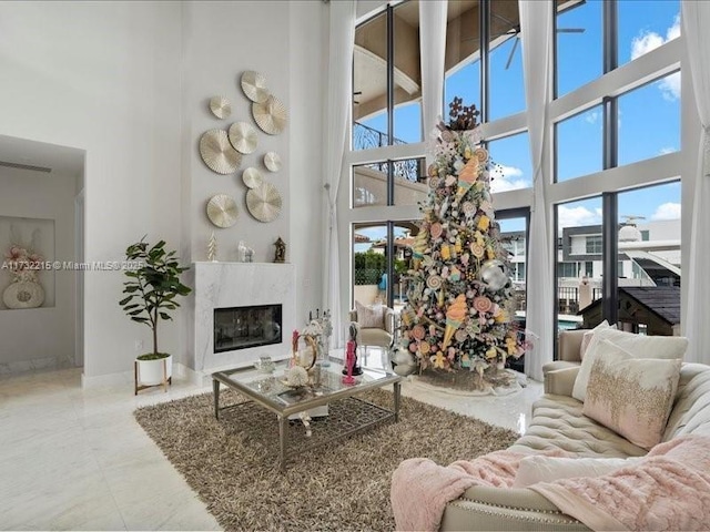 living room featuring a fireplace and a high ceiling