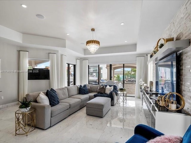 living room featuring an inviting chandelier and a raised ceiling