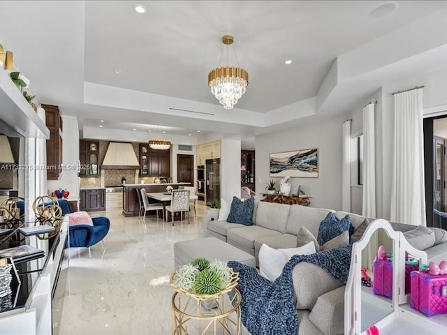 living room featuring a notable chandelier and a raised ceiling