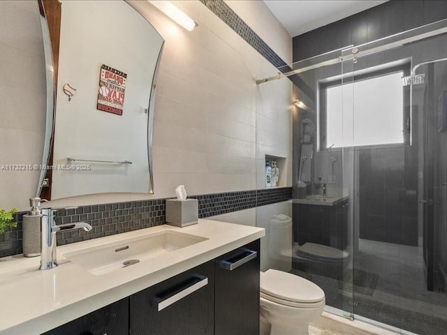 bathroom with vanity, backsplash, toilet, and walk in shower