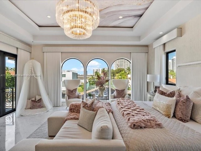 bedroom featuring french doors, a tray ceiling, access to exterior, and a notable chandelier