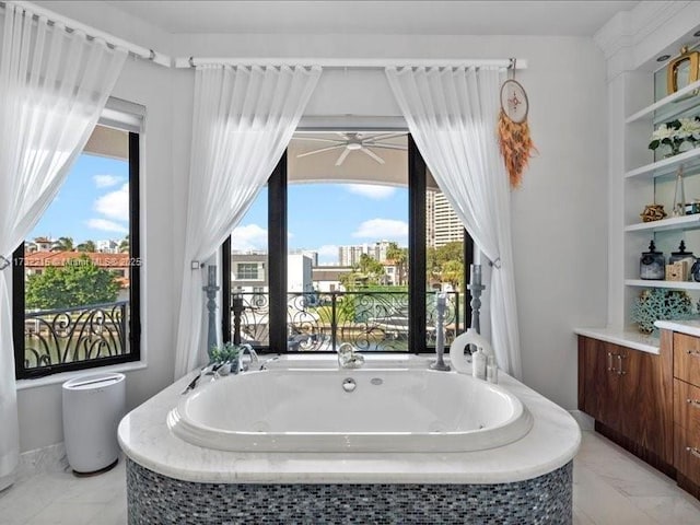 bathroom featuring a relaxing tiled tub, ceiling fan, and vanity