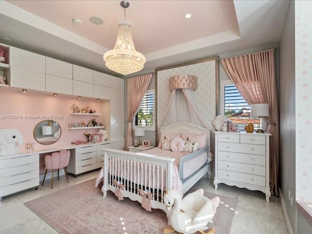 bedroom with built in desk, a chandelier, and a tray ceiling