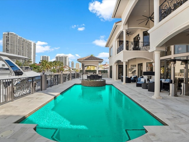 view of swimming pool featuring a gazebo, an outdoor hangout area, ceiling fan, and a patio area