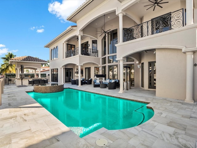 view of swimming pool featuring ceiling fan, an outdoor hangout area, and a patio