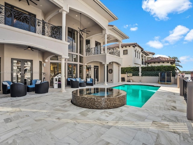 view of swimming pool featuring a patio, outdoor lounge area, and ceiling fan