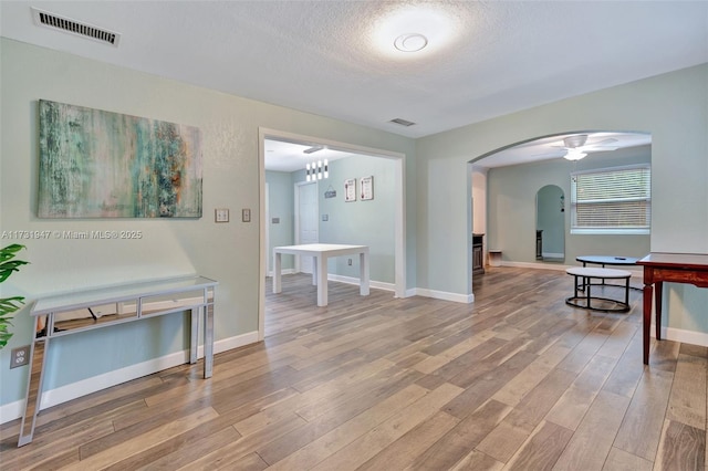 hallway with hardwood / wood-style floors and a textured ceiling