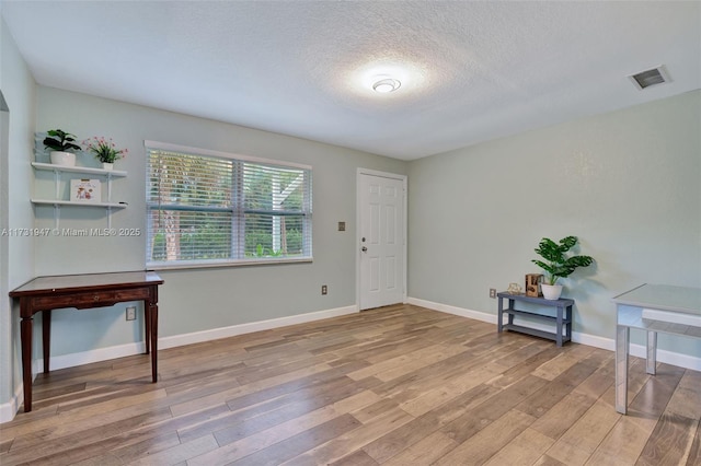 interior space featuring hardwood / wood-style flooring and a textured ceiling