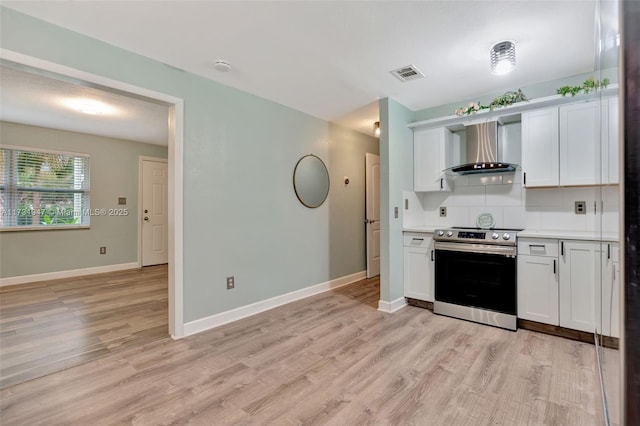 kitchen with electric stove, white cabinets, backsplash, and wall chimney exhaust hood