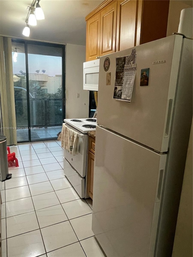 kitchen with light tile patterned flooring, white appliances, a wall of windows, and light brown cabinets