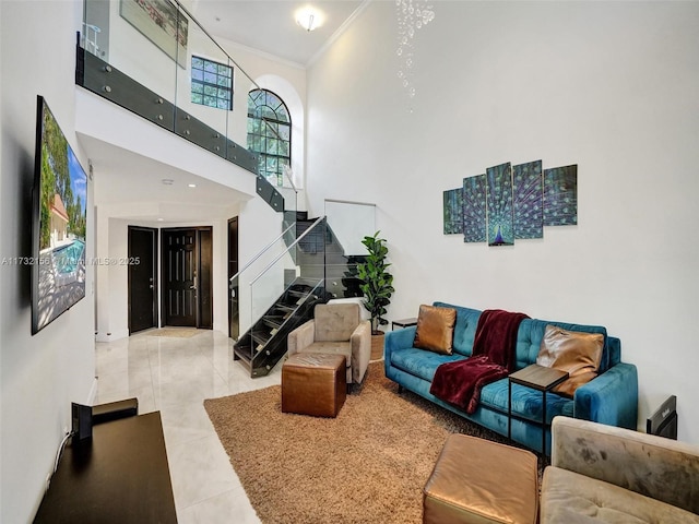 living area with stairs, a high ceiling, tile patterned flooring, and crown molding