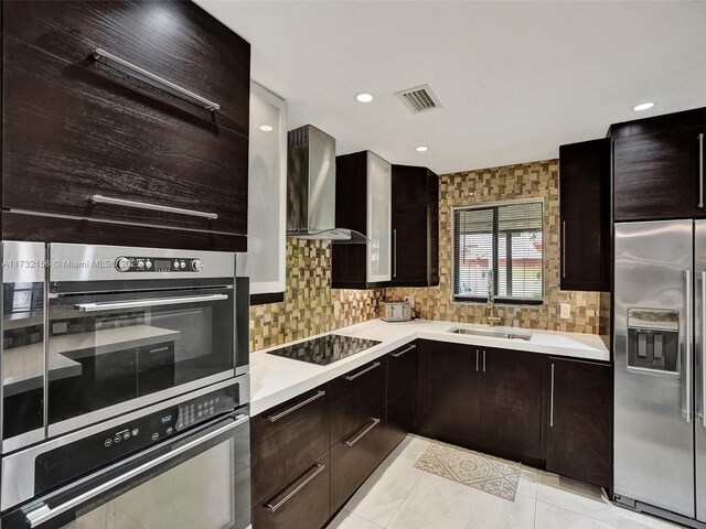 kitchen featuring high quality fridge, decorative light fixtures, tasteful backsplash, sink, and a center island