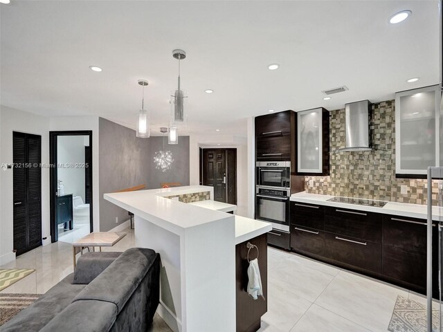 kitchen with wall chimney range hood, light tile patterned floors, sink, appliances with stainless steel finishes, and tasteful backsplash