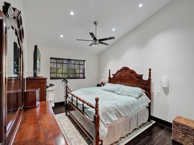 bedroom with dark hardwood / wood-style flooring, lofted ceiling, and ceiling fan