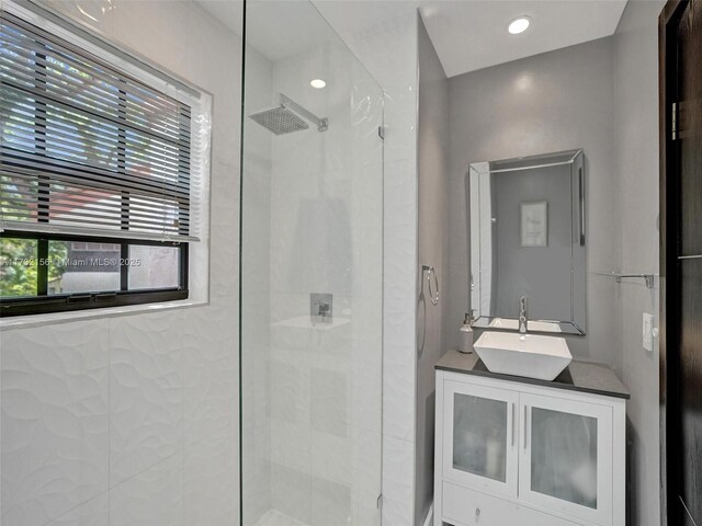 bathroom featuring a tile shower and vanity