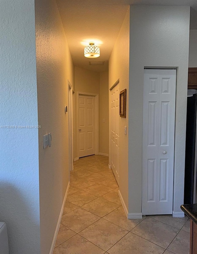 hall with light tile patterned floors