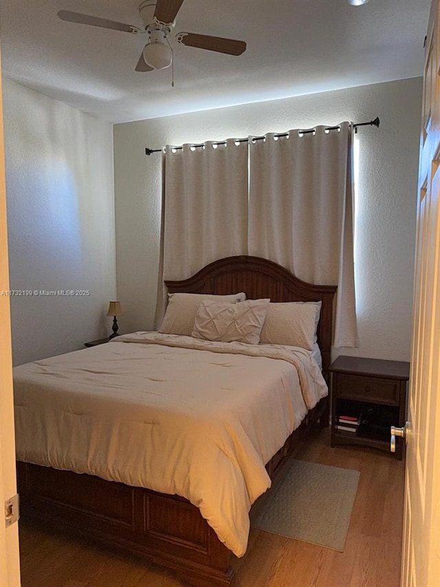 bedroom with hardwood / wood-style floors and ceiling fan