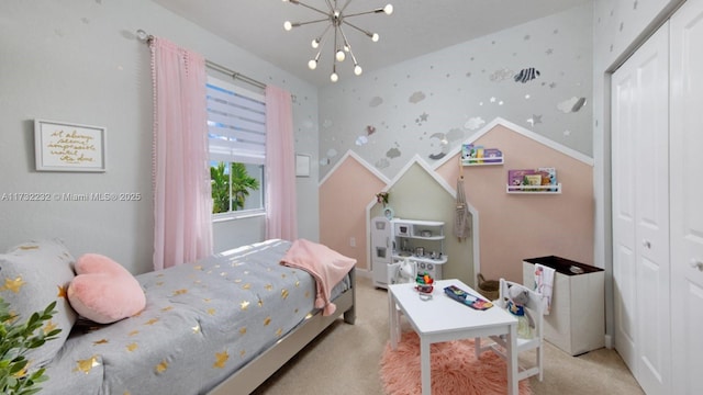 bedroom featuring light colored carpet, a closet, and a notable chandelier