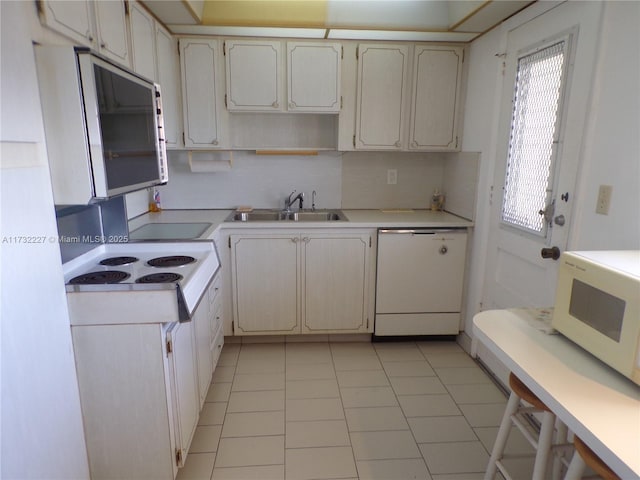 kitchen with white cabinets, white appliances, sink, and light tile patterned floors