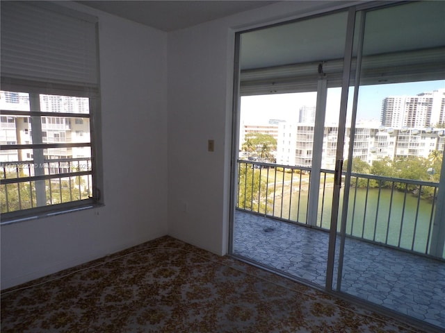 carpeted empty room featuring a view of city