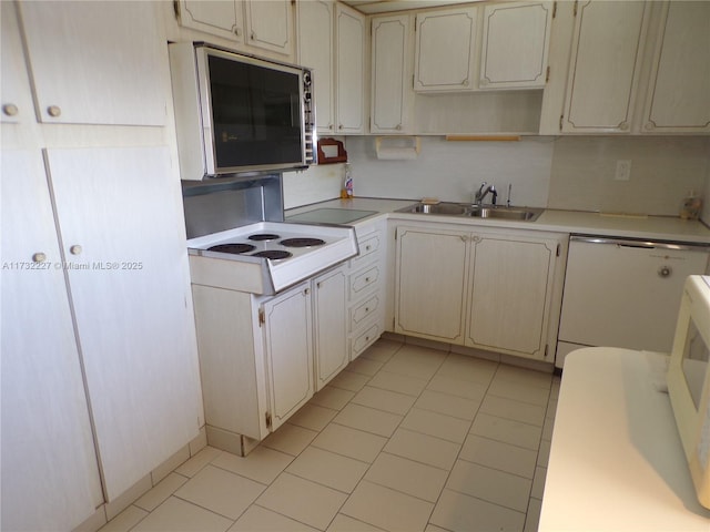 kitchen featuring dishwasher, light countertops, stainless steel microwave, and a sink