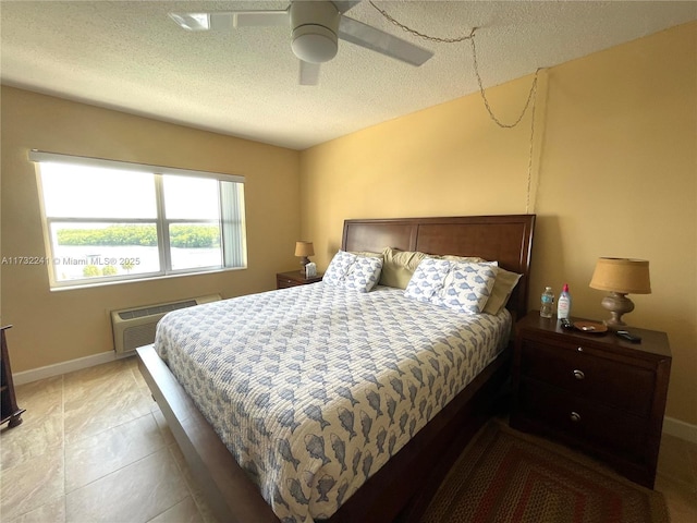 bedroom with an AC wall unit, a textured ceiling, and ceiling fan