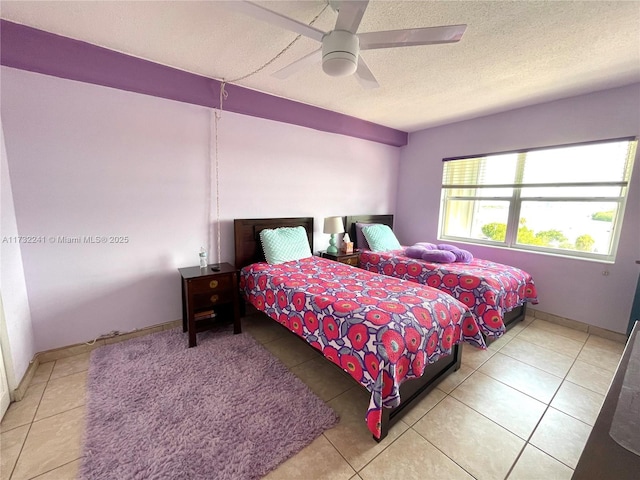 bedroom with a textured ceiling, ceiling fan, and light tile patterned flooring