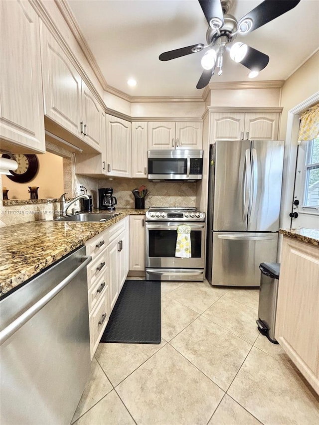 kitchen featuring stainless steel appliances, stone countertops, sink, and light tile patterned floors