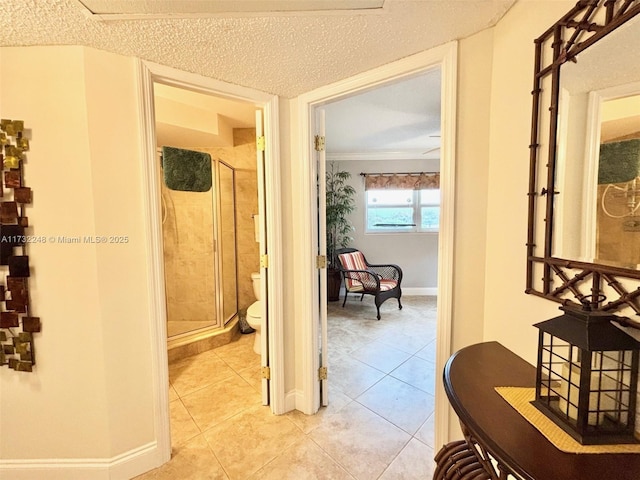 hall featuring crown molding, a textured ceiling, and light tile patterned flooring