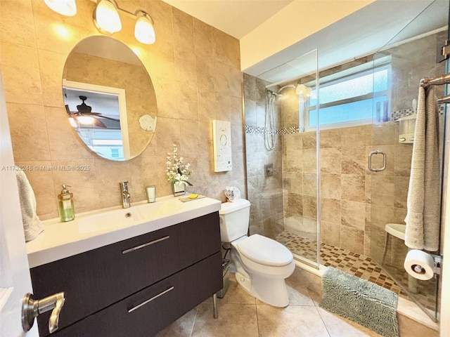 bathroom with tile walls, vanity, an enclosed shower, toilet, and tile patterned floors