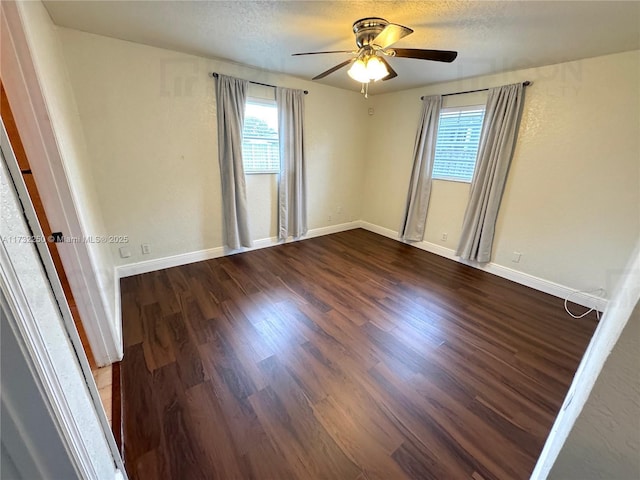 unfurnished room featuring dark hardwood / wood-style flooring, ceiling fan, and a textured ceiling