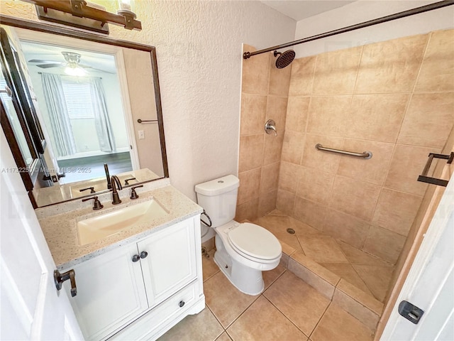 bathroom featuring vanity, toilet, tile patterned flooring, and a tile shower